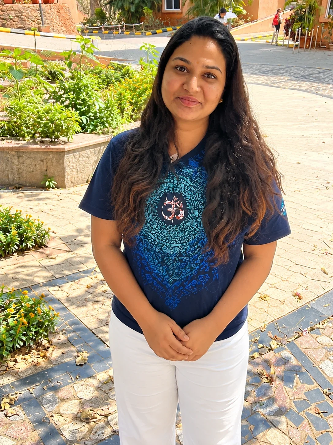 Niharika, founder of Deha Pragnya Healing Center, standing outdoors in a sunlit garden